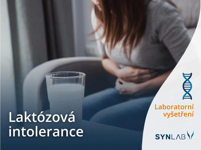 Žena drží břicho v bolesti vedle sklenice mléka při laktózové intoleranci.