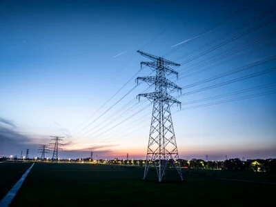 Vysoké elektrické věže na pozadí západu slunce.