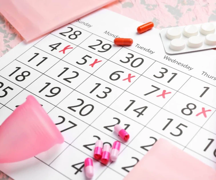 Kalendář s označením menstruace a hygienické produkty pro ženy.