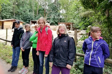 Skupina lidí venku v přírodě usmívá se do kamery.
