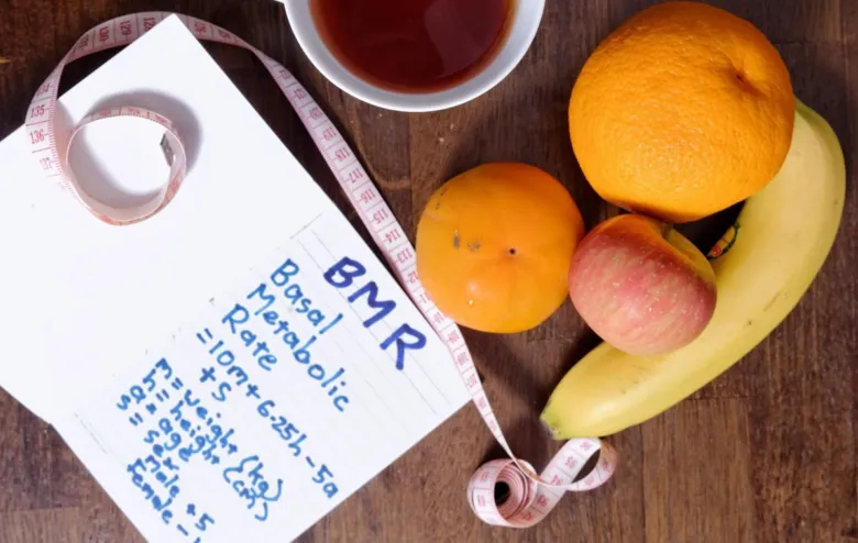 Zápis vzorce pro výpočet bazálního metabolismu s ovocem a páskou.