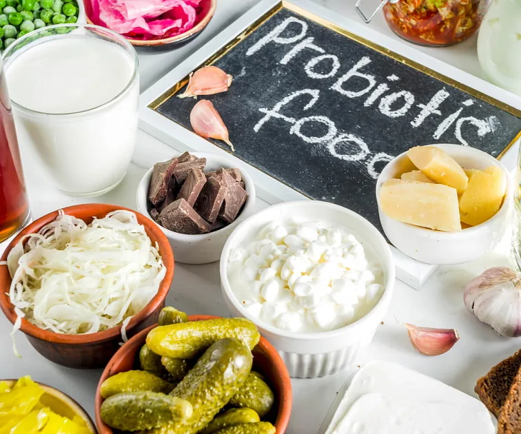 Přirozená probiotická jídla jako jogurt, okurky a zelí pro zdravé střeva.