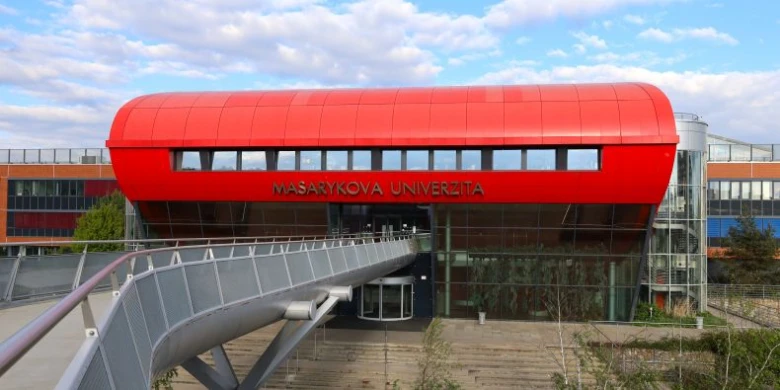 Moderní budova Masarykovy univerzity s červenou střechou.