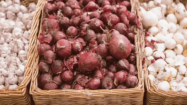 Korze s červenou cibulí, česnekem a šalotkou na trhu.
