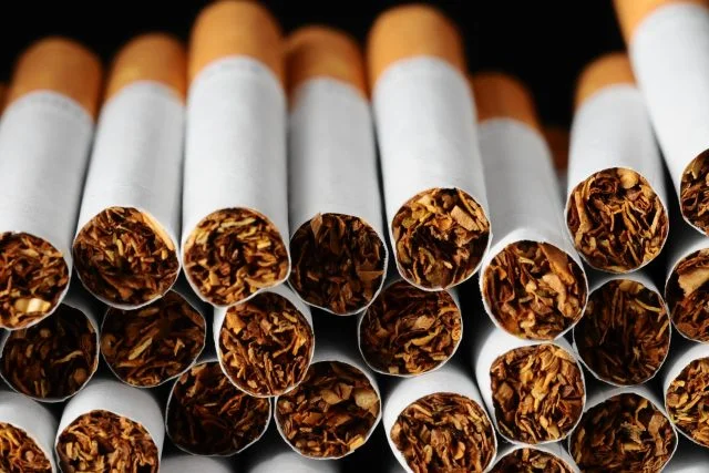 Hromada cigaret s viditelným tabákem uvnitř.
