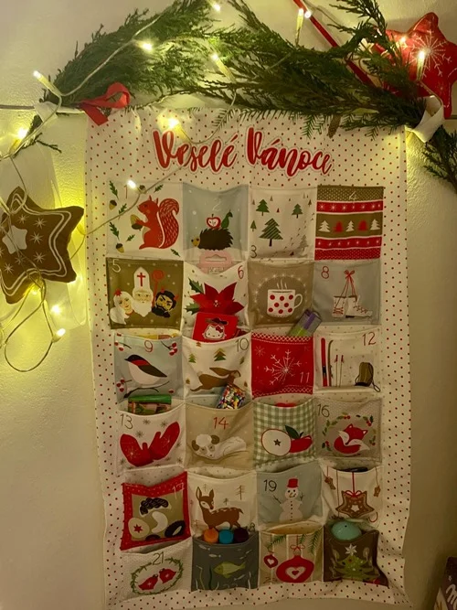 Vánoční kalendář s dárky pro děti na zdi.