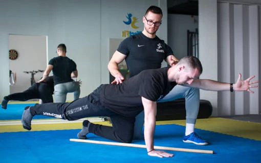 Trénink s instruktorem pro začátečníky v posilovně.