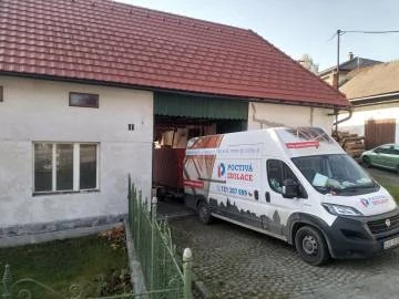Nákladní vůz firmy na zateplování stojí u domu při rekonstrukci.