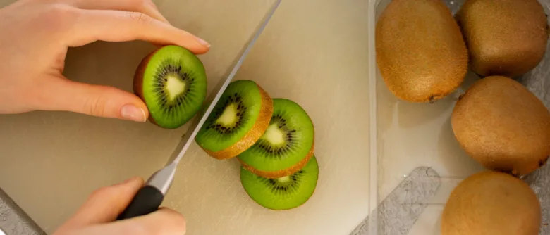 Rezání čerstvého kiwi na plátky pro příprava vitamínu C
