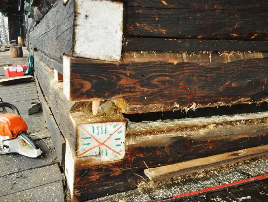 Detail renovované dřevěné chalupy s řezacím pilou pro zachování rustikálního rázu