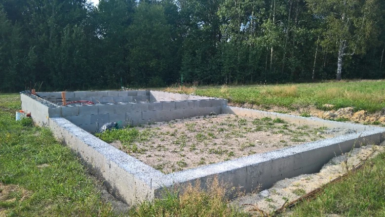 Nově nalité betonové základy obklopené dřevěným bedněním.