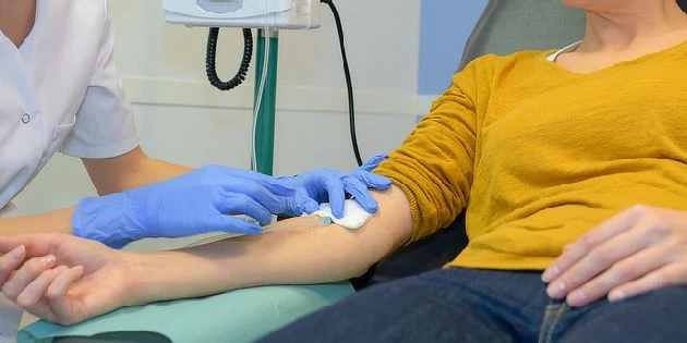 Zdravotník připravuje pacientovi krevní odběr v ordinaci.