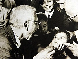 Starosta se usmívá na děti v historické fotografii.