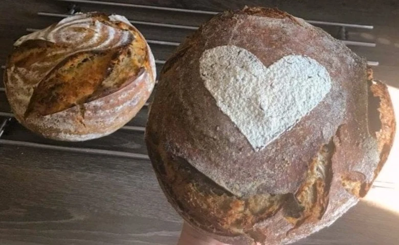 Dva celozrnné chleby na mřížce s výraznou kůrkou.