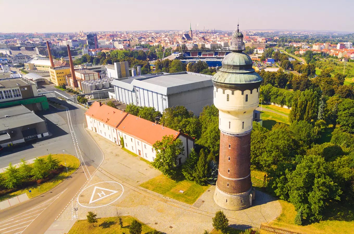 Historická vodní věž v Plzni s okolním průmyslovým areálem.