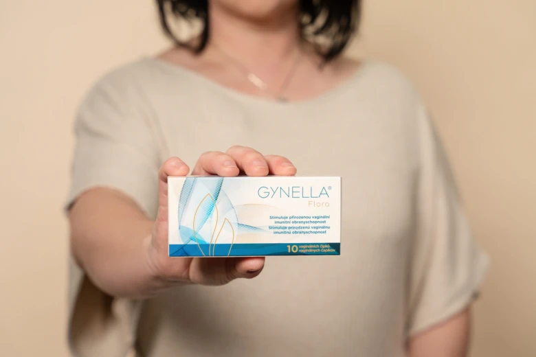 Žena drží krabičku doplnku pro vaginální zdraví značky Gynella.