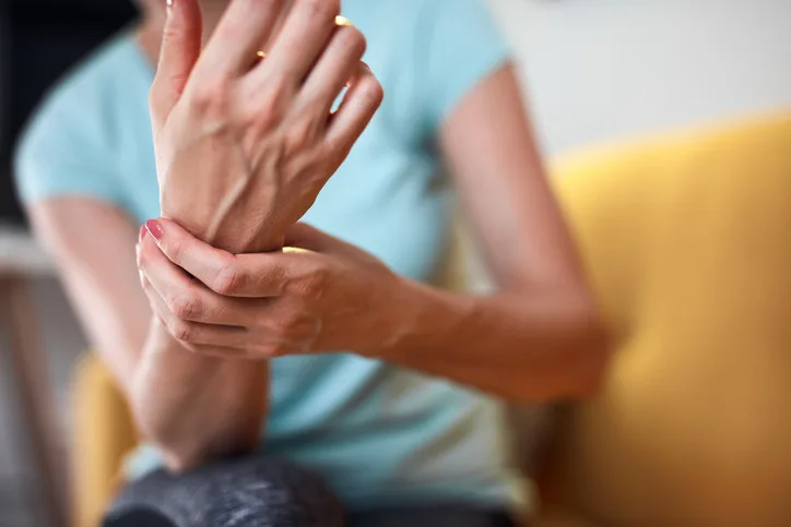 Žena drží ruku v bolesti kvůli polyneuropatii