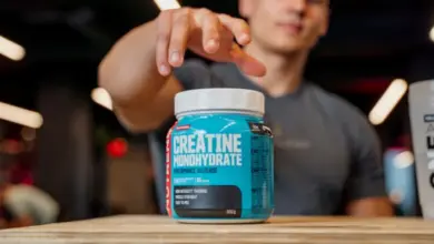 Modrá nádoba s kreatinem na dřevěném stole.