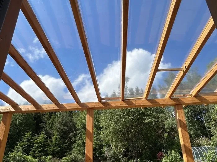 Pergula s průsvitnou střechou pod modrou oblohou