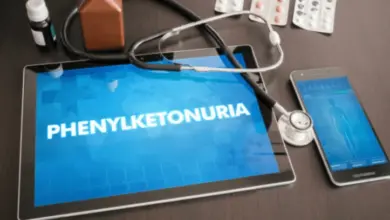 Tablet s textem fenylketonurie obklopený lékařskými předměty.