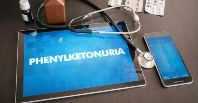 Tablet s textem fenylketonurie obklopený lékařskými předměty.