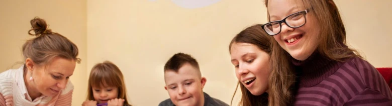 Skupina šťastných lidí se dívá dolů na něco mimo záběr.