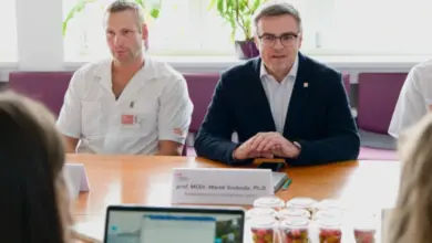 Dva lékaři sedí za stolem během schůzky o léčbě nádoru slinivky.