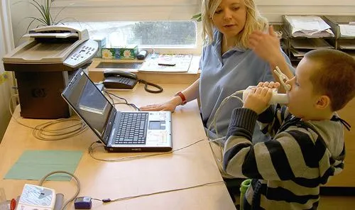 Dětská spirometrie: chlapec dýchá do přístroje při vyšetření.