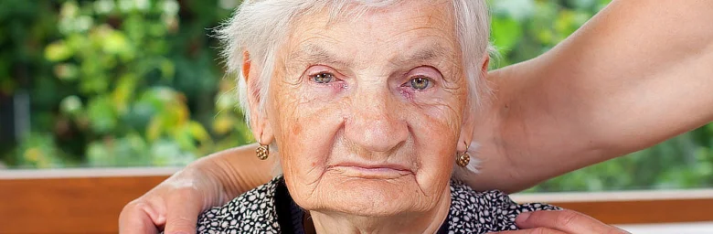 Starší žena s vyjadřováním smutku nebo úzkosti.