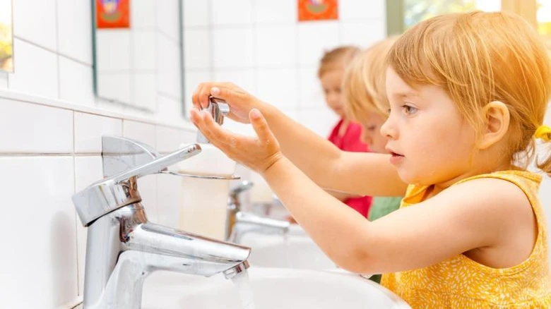 Dětský lékař ukazuje na mytí rukou jako prevenci proti roupům.