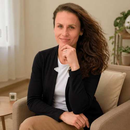 Žena sedí na gauči v interiéru s myšlenkami.