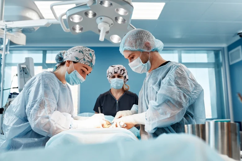 Chirurgové operují pacienta v operační sále.