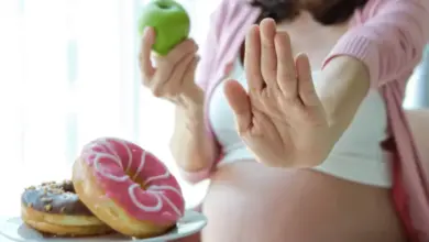 Těhotná žena odmítá sladkosti ve prospěch jablka.