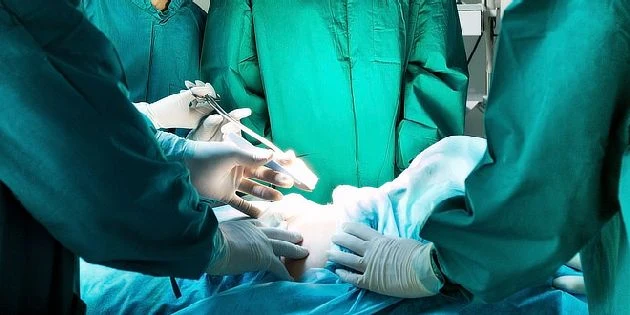 Chirurgové provádějí operaci na pacientovi v nemocničním prostředí.