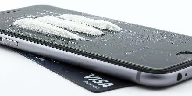 Bílý prášek na displeji mobilního telefonu