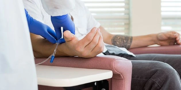 Zdravotník provádí odběr krve pacientovi v ordinaci.
