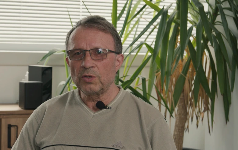 Muž s mikrofonem vysvětluje afázii v interiéru.