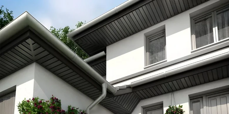 Moderní dům s tmavými plastovými podhledy na okapových střešních svazích.