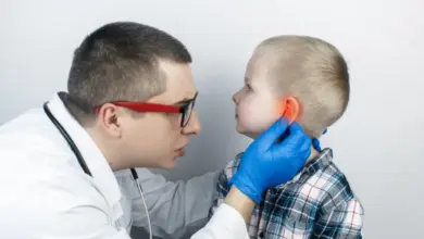 Lékař vyšetřuje zánět zevního zvukovodu u dítěte.