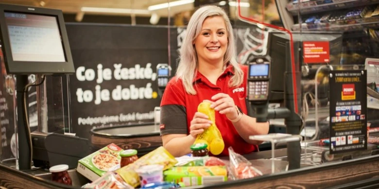 Kasírka drží žluté těstoviny z konjaku za pokladnou.